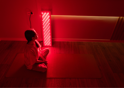 A woman performing LED light therapy treatment at home 