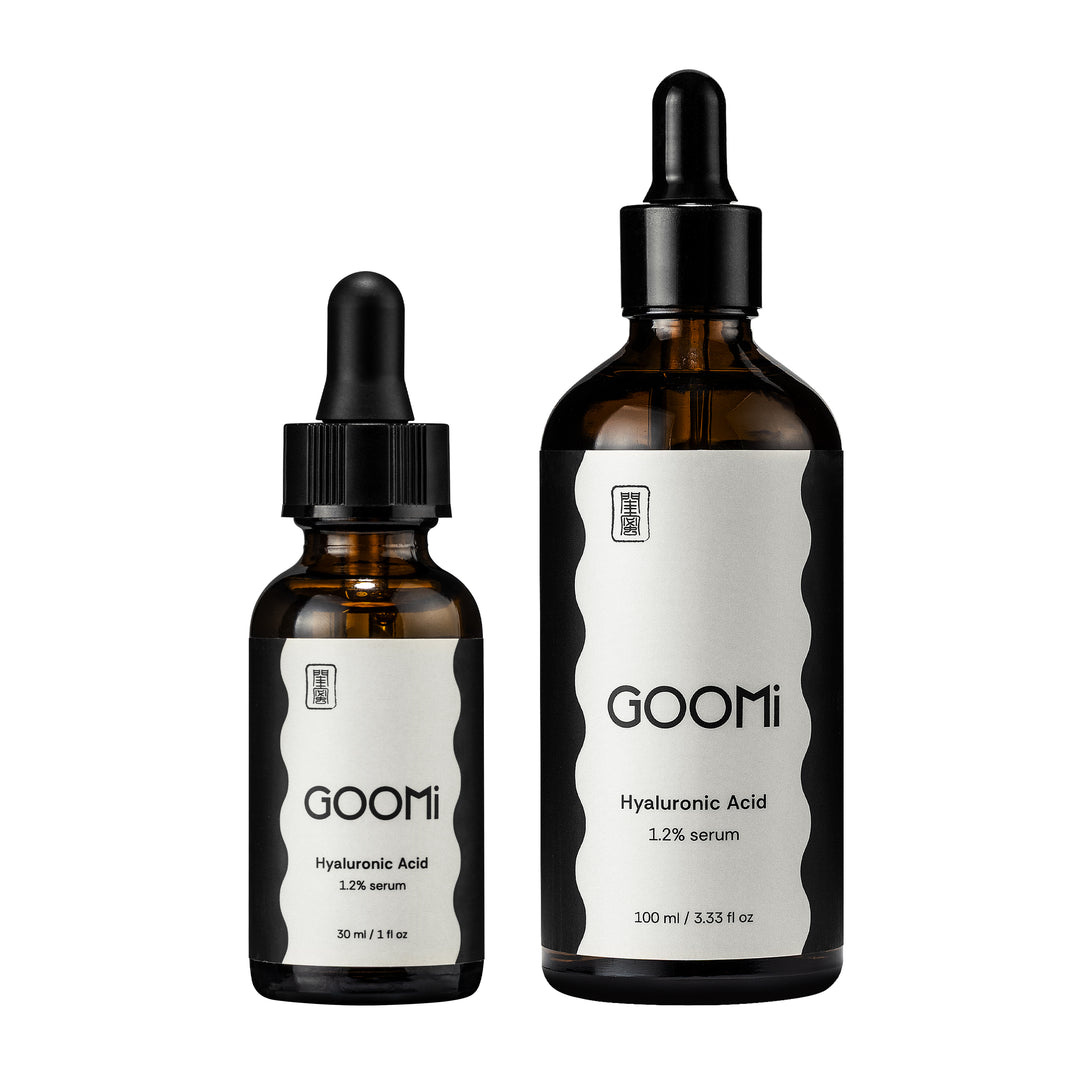 2 glass dropper bottles of GOOMi Hyaluronic Acid serum, one 30 ml and one 100 ml, with black caps and white labels on a plain white background.